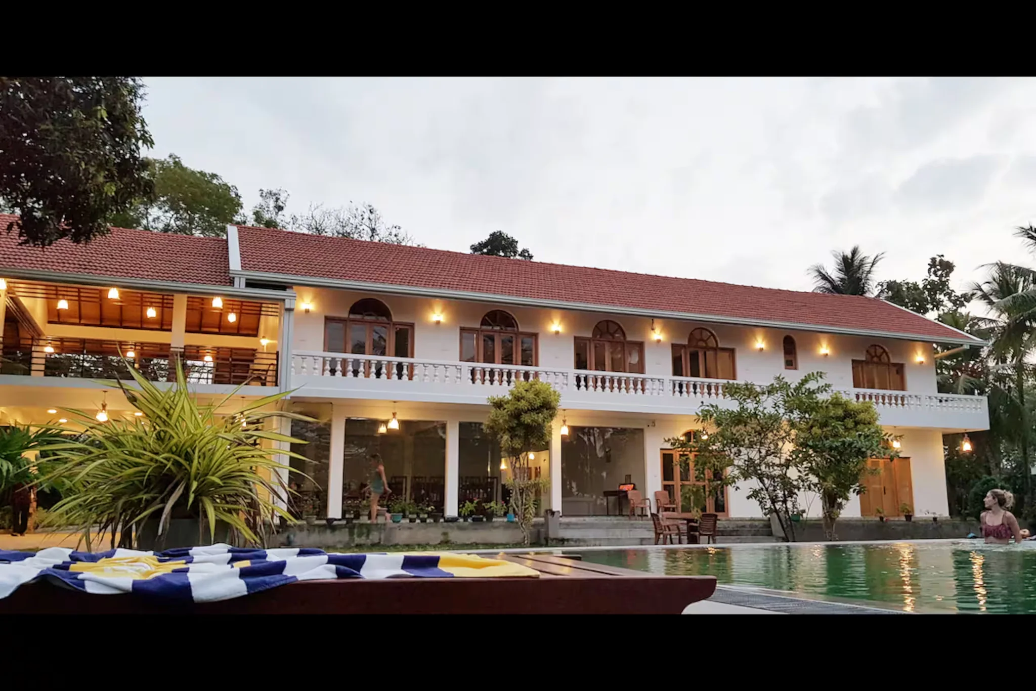 The existing villa photographed at dusk with its lights on